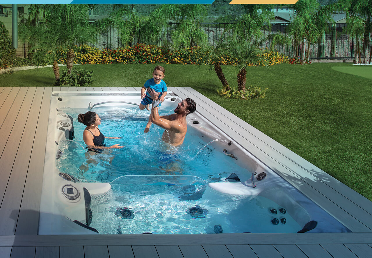 Michael Phelps and family enjoying a swim spa surrounded by a deck and lawn